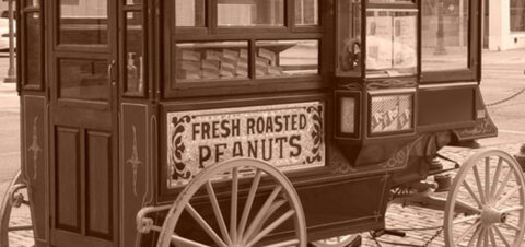 an old photo of a carriage selling fresh roasted peanuts.
