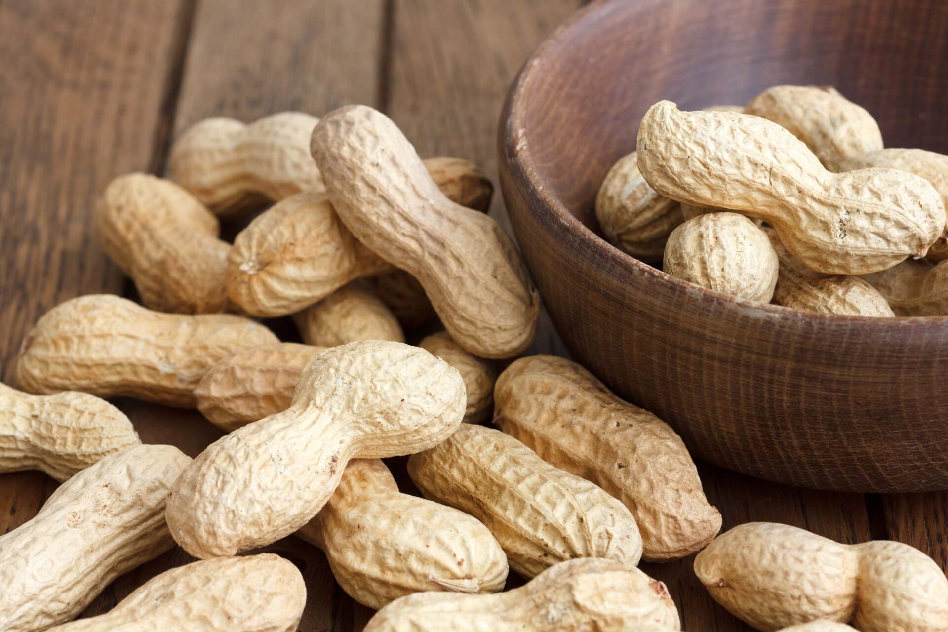 Rustic wood bowl of peanuts in shells