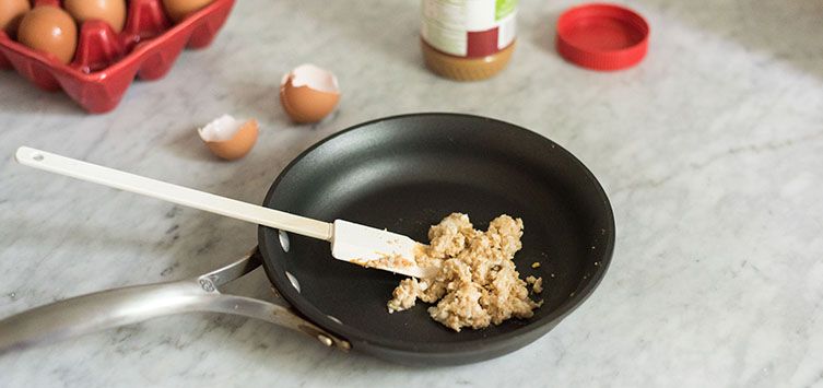 a pan with scrambled eggs on top of a marble counter.