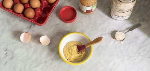a table topped with eggs and a bowl of oatmeal.