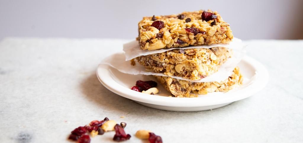 three granola bars made of peanuts and dry fruits.