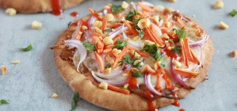 a flatbread topped with chopped carrots